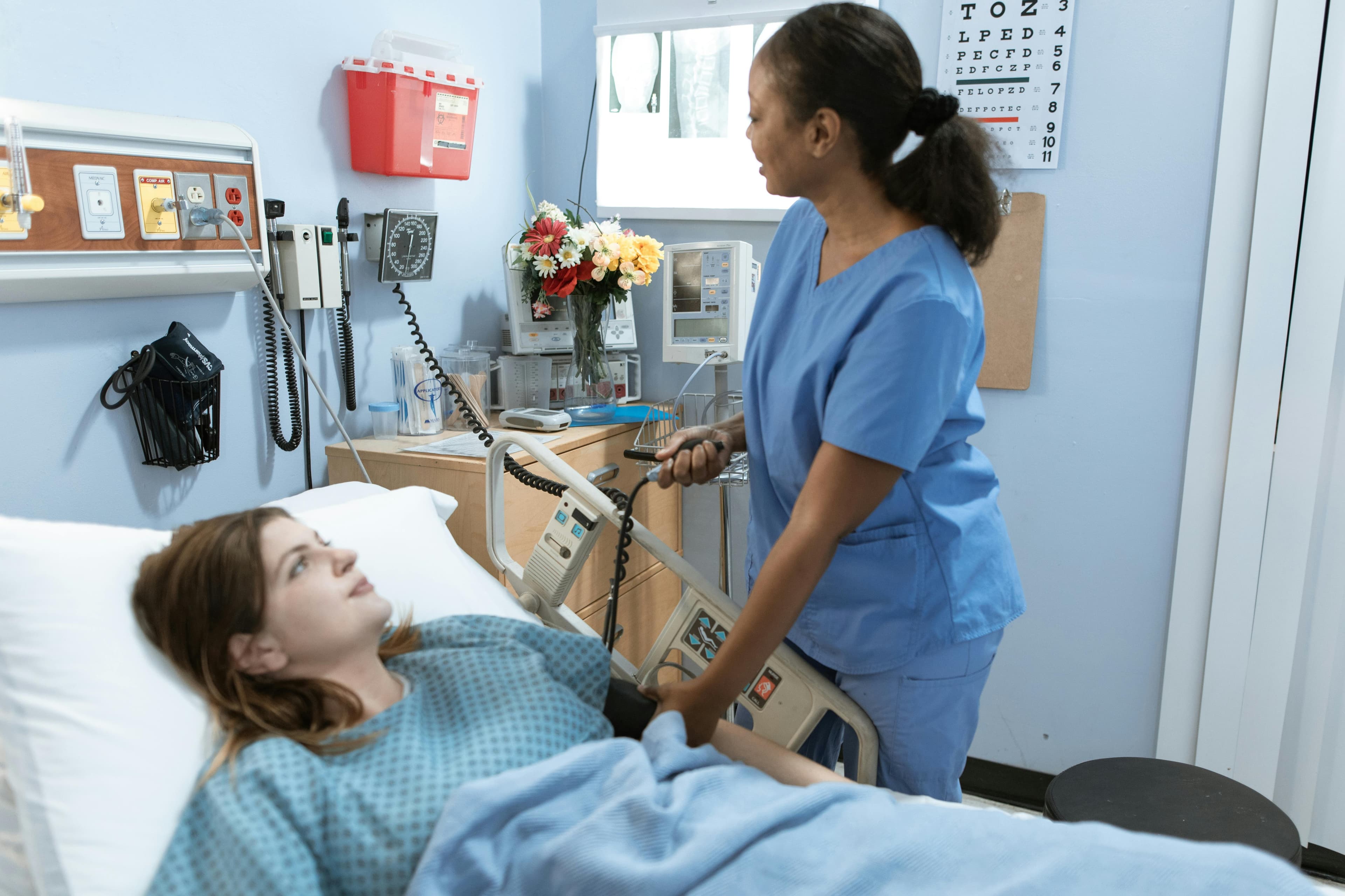 Nurse helping bed patient